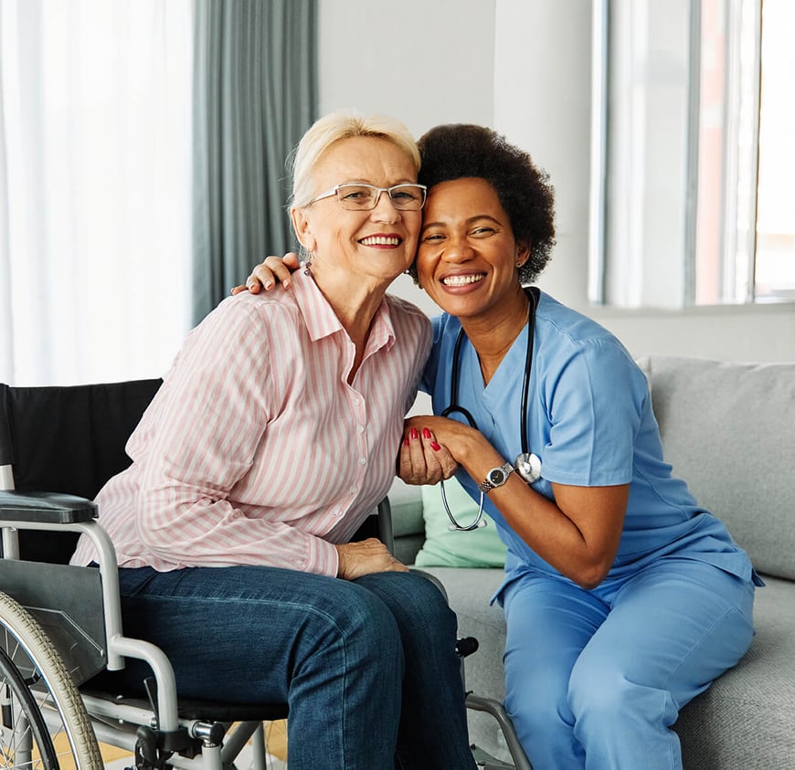 Female nurse and patient smiling together looking at camera